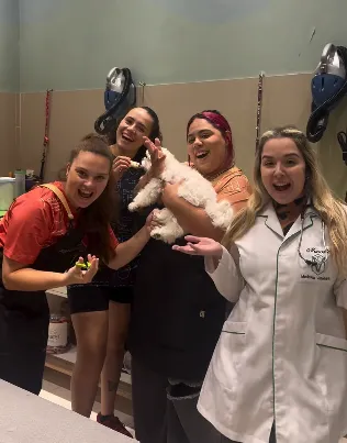 Equipe da Praia do Pet sorrindo com um pet no colo