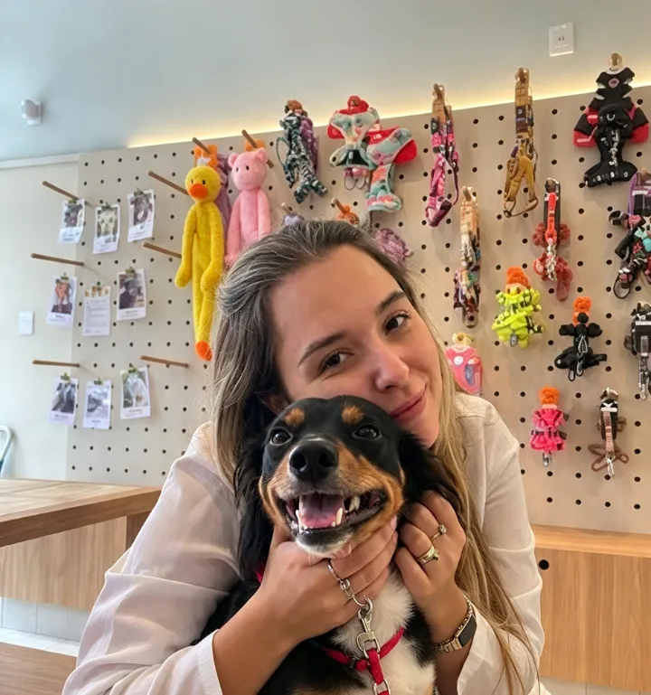 Profissional abraçando um cachorro sorridente na loja